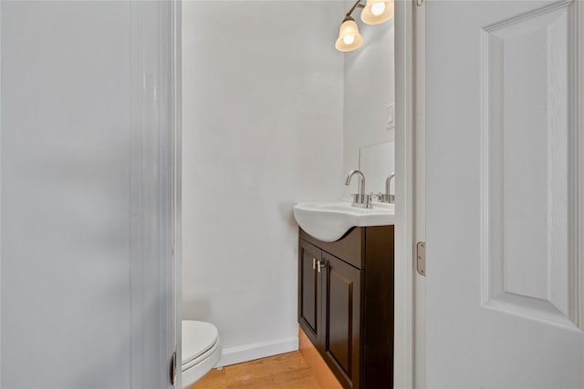 bathroom featuring hardwood / wood-style floors, toilet, and vanity