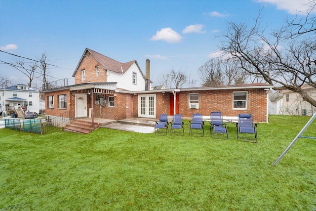 rear view of house featuring a patio area, french doors, and a lawn