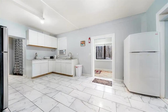 kitchen featuring white refrigerator, white cabinetry, sink, and stainless steel refrigerator