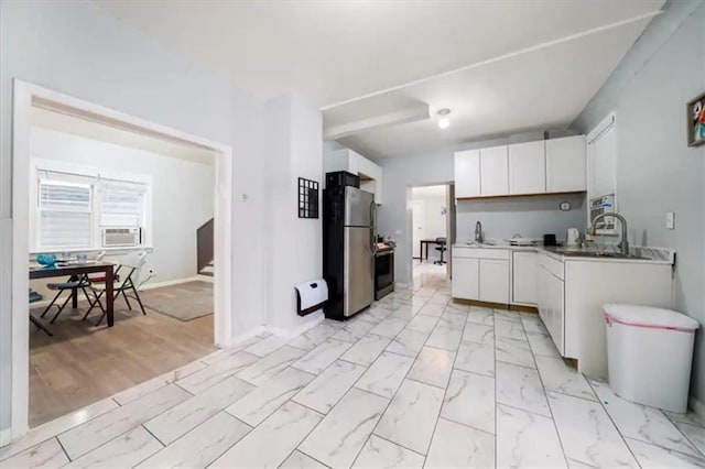 kitchen with stainless steel refrigerator, white cabinetry, sink, and cooling unit