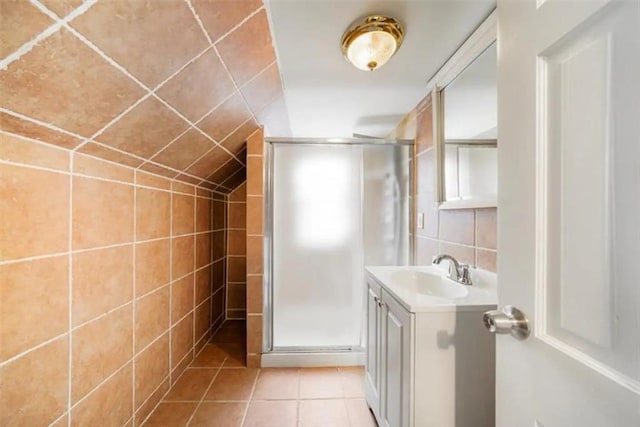 bathroom featuring tile walls, tile patterned flooring, backsplash, vanity, and a shower with shower door