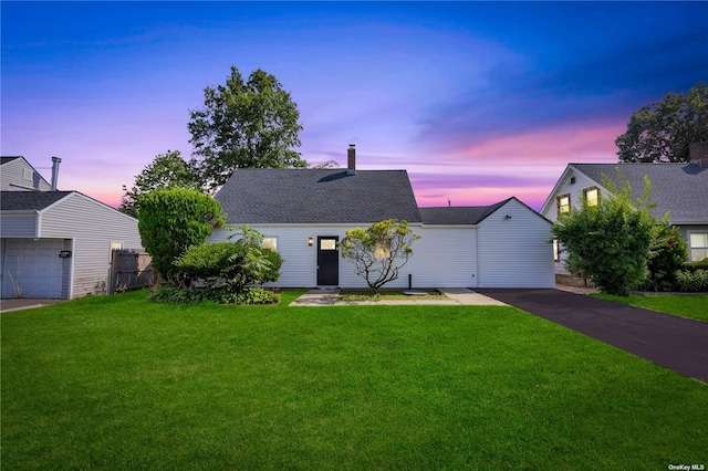 view of front of house with a garage and a yard