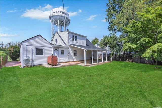 rear view of house with a lawn, ac unit, and a patio