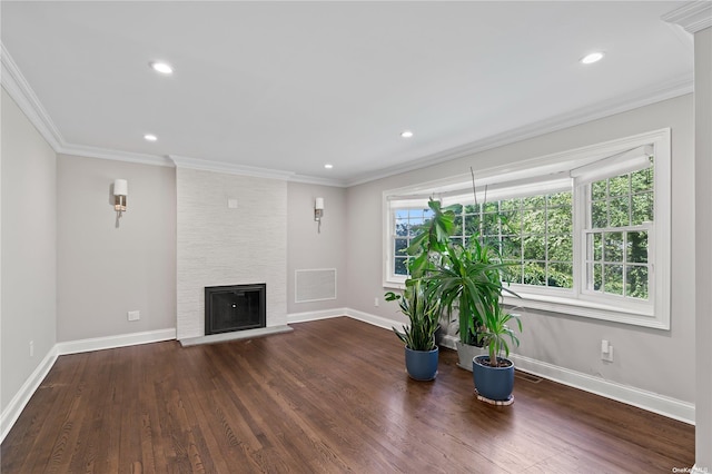 unfurnished living room with a large fireplace, dark wood-type flooring, and crown molding