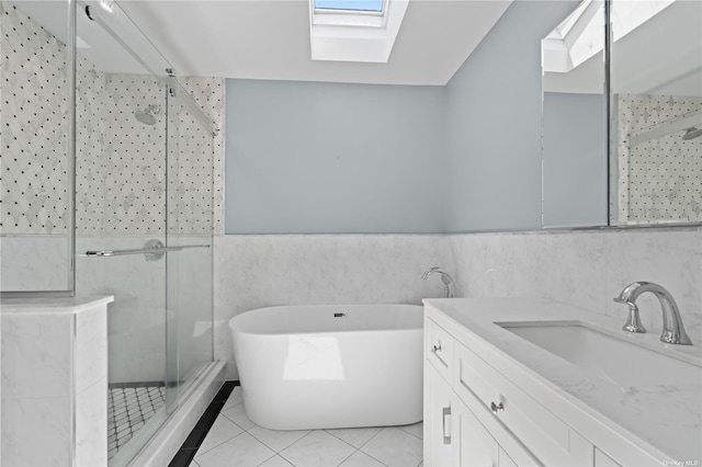 bathroom featuring tile patterned flooring, tile walls, a skylight, independent shower and bath, and vanity