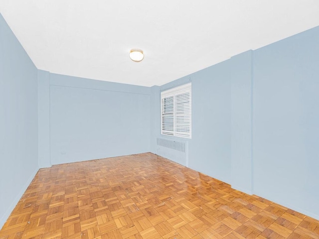 empty room with radiator heating unit and light parquet flooring