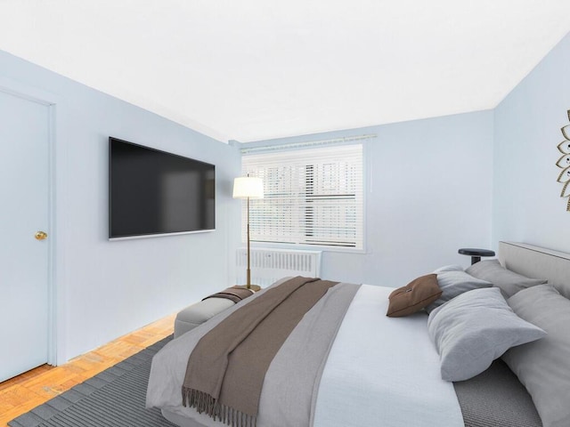 bedroom featuring radiator heating unit and hardwood / wood-style floors