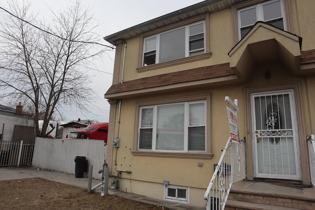 view of front of property with fence and stucco siding