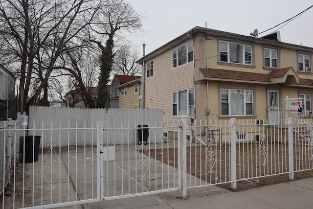 view of front facade featuring a fenced front yard and a gate