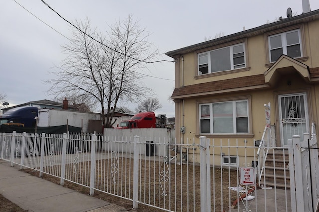 view of front of property with a fenced front yard and stucco siding