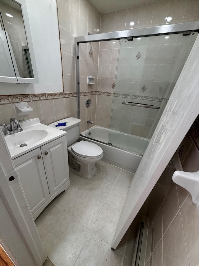 full bath featuring tile walls, toilet, enclosed tub / shower combo, vanity, and tile patterned floors