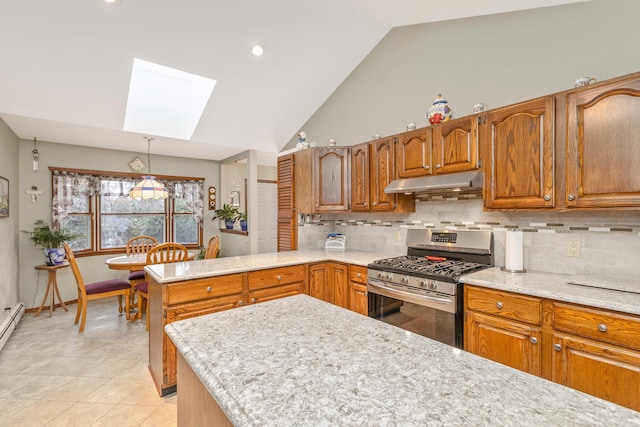 kitchen featuring a skylight, decorative backsplash, stainless steel gas stove, and high vaulted ceiling