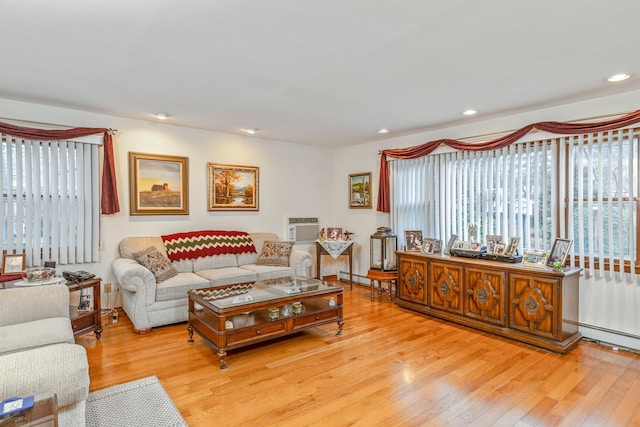 living room with a wall mounted AC, plenty of natural light, a baseboard radiator, and light hardwood / wood-style floors