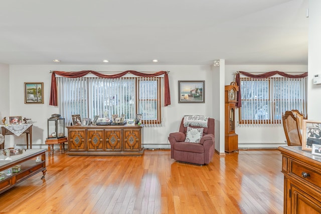 sitting room featuring baseboard heating and light hardwood / wood-style flooring