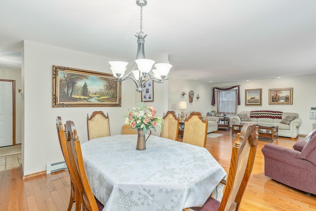 dining space featuring a baseboard radiator, a notable chandelier, and light wood-type flooring