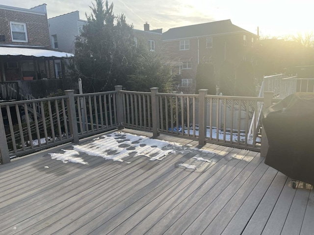 deck at dusk featuring a grill