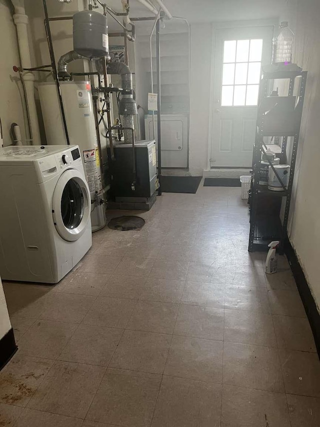 clothes washing area featuring washer / clothes dryer and water heater