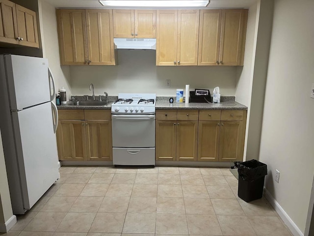 kitchen with sink, white appliances, dark stone counters, and light tile patterned flooring