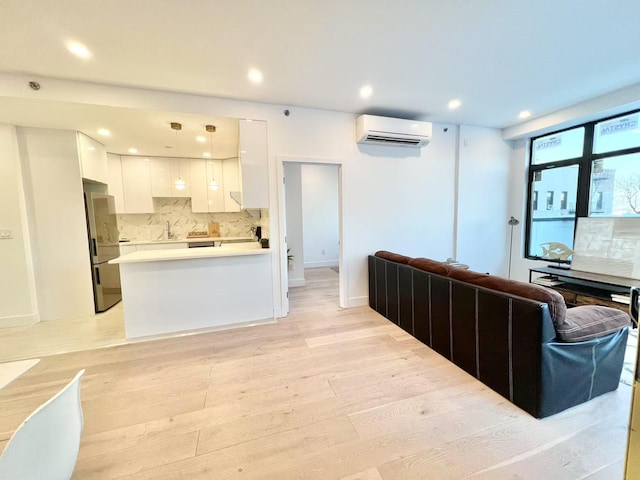 living room with light hardwood / wood-style floors and an AC wall unit