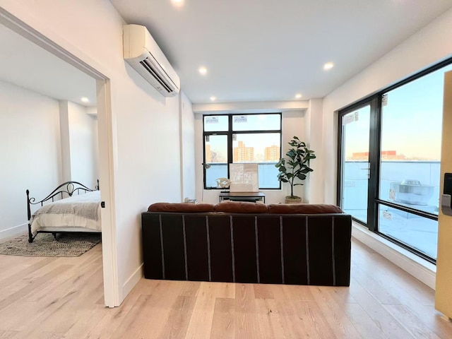 interior space with an AC wall unit, a healthy amount of sunlight, and light hardwood / wood-style floors