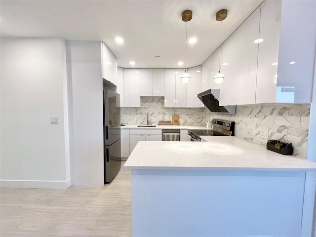 kitchen featuring white cabinetry, decorative light fixtures, kitchen peninsula, and appliances with stainless steel finishes