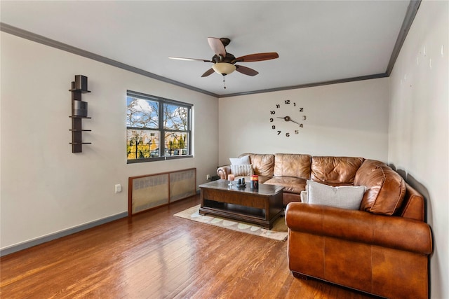 living room with wood-type flooring, ceiling fan, and crown molding