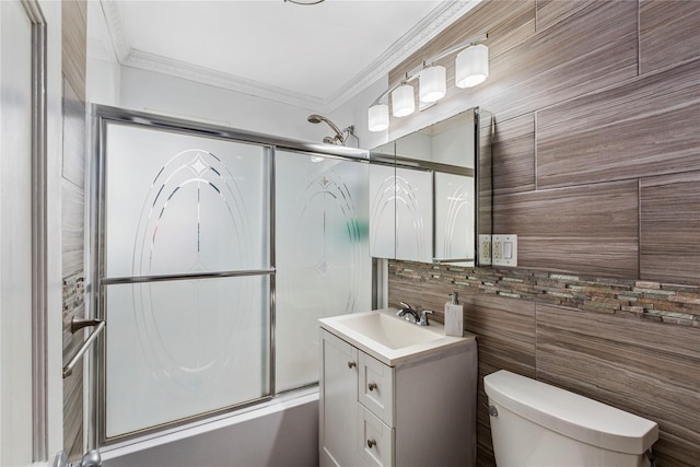 full bathroom featuring toilet, crown molding, vanity, shower / bath combination with glass door, and backsplash