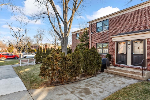 exterior space featuring cooling unit and a front lawn