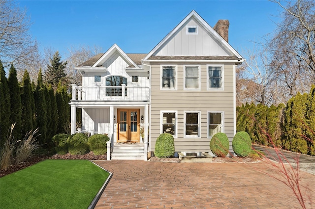 view of front of home featuring a front lawn, french doors, and a balcony