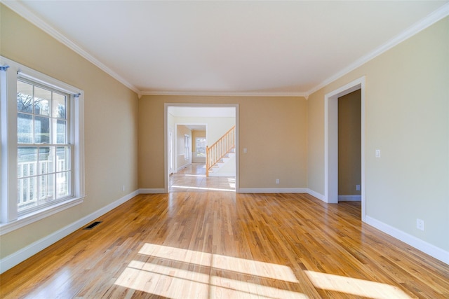 spare room featuring crown molding and light hardwood / wood-style floors