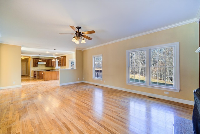 unfurnished living room featuring a healthy amount of sunlight, crown molding, and light hardwood / wood-style flooring