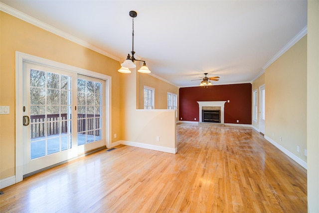 unfurnished living room featuring ceiling fan with notable chandelier, crown molding, and light wood-type flooring