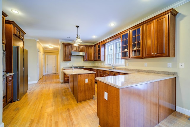 kitchen featuring a center island, hanging light fixtures, kitchen peninsula, light stone counters, and crown molding