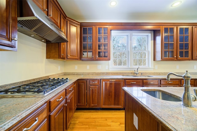 kitchen featuring light stone counters, sink, and stainless steel gas cooktop