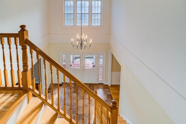 stairway featuring a notable chandelier