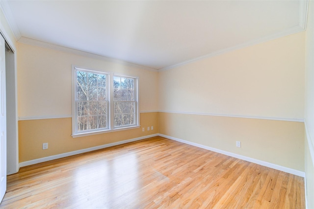 unfurnished room featuring light hardwood / wood-style floors and crown molding