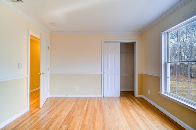 unfurnished bedroom with light wood-type flooring, a closet, and ornamental molding