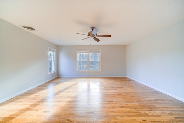 empty room with ceiling fan and light hardwood / wood-style flooring