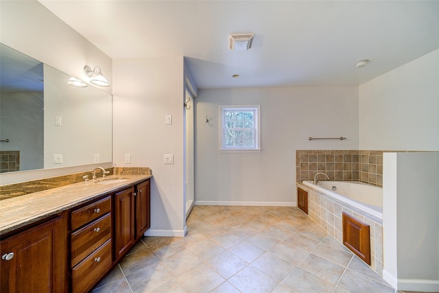 bathroom with tiled bath, tile patterned floors, and vanity