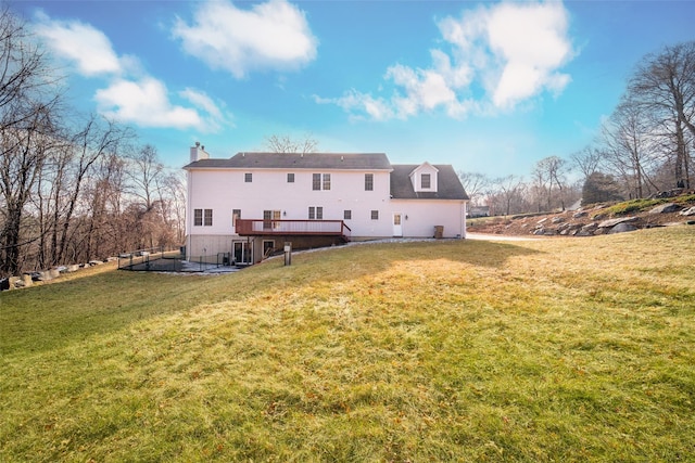 rear view of house featuring a deck and a lawn