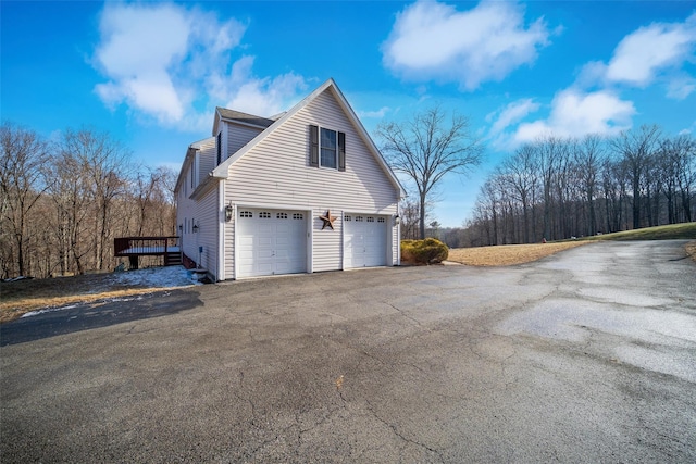 view of property exterior featuring a deck and a garage