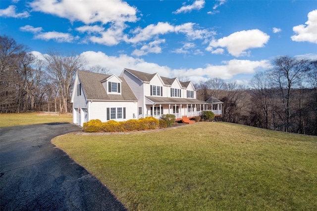 cape cod-style house featuring covered porch, a garage, and a front lawn