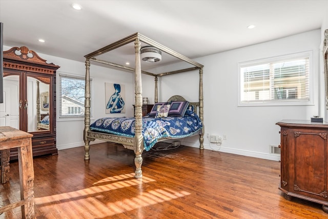 bedroom with hardwood / wood-style floors and multiple windows