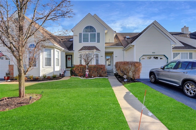 view of front of home with a garage and a front lawn