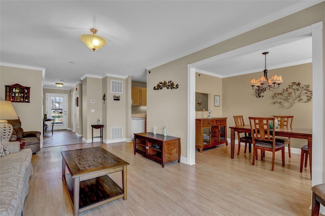 living room featuring an inviting chandelier, crown molding, and light hardwood / wood-style floors