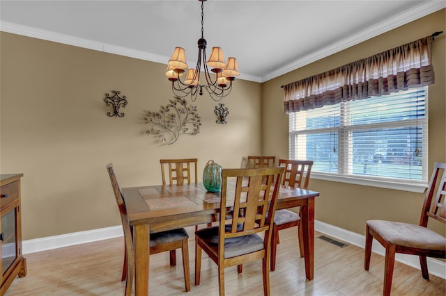 dining space featuring light hardwood / wood-style floors, crown molding, and a chandelier