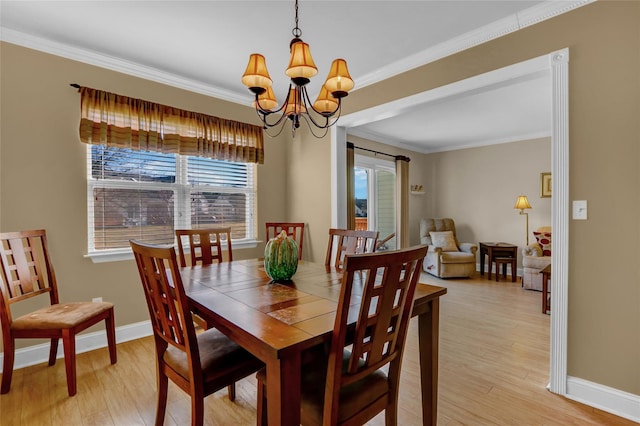 dining room with light wood-type flooring, crown molding, and an inviting chandelier