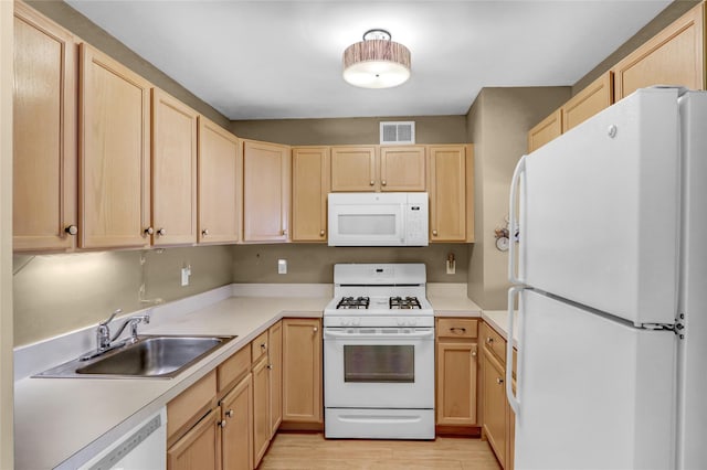 kitchen with light brown cabinetry, sink, light hardwood / wood-style flooring, and white appliances