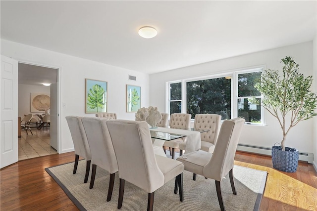 dining room with hardwood / wood-style flooring and baseboard heating