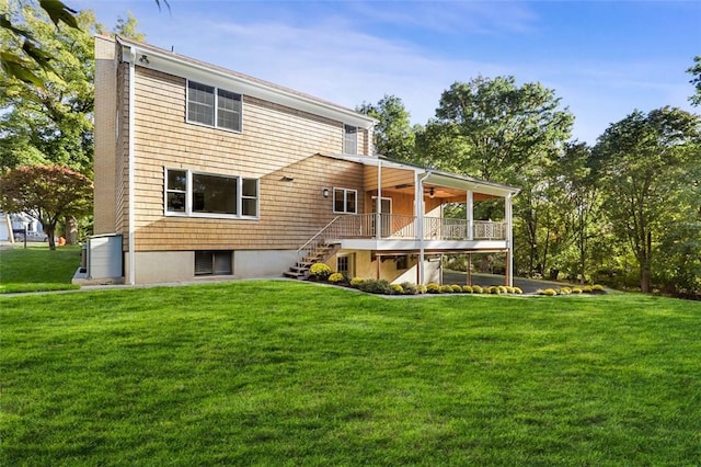 rear view of house featuring a yard and ceiling fan